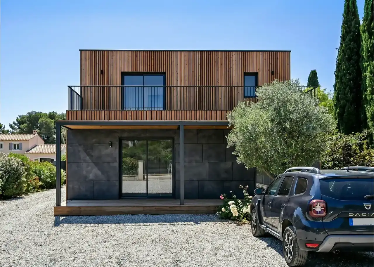 Maison ossature bois Greenkub à étage, bardage bois et terrasse couverte, implantée sur son terrain