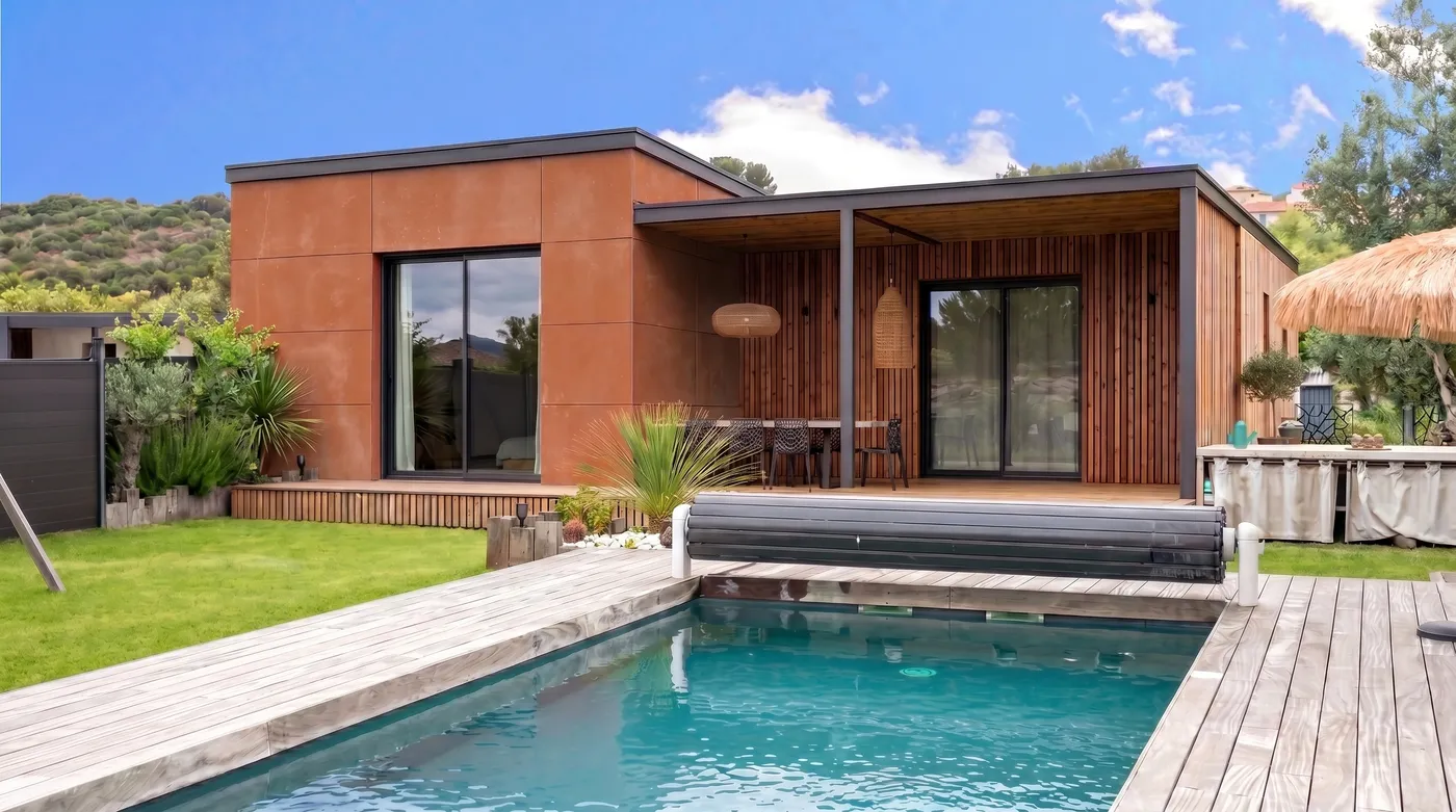 Couleur de façade rouge sur la maison Greenkub MI60L, claire-voie bois naturel