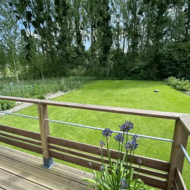 Terrasse d’une maison en bois avec un grand jardin