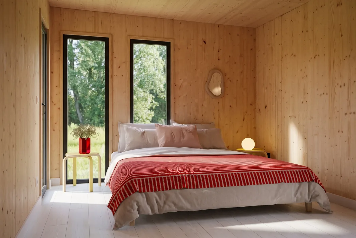 Intérieur du studio GK25 de 25 m² : coin salon d'accueil, baie vitrée et parement en bois massif épicéa
