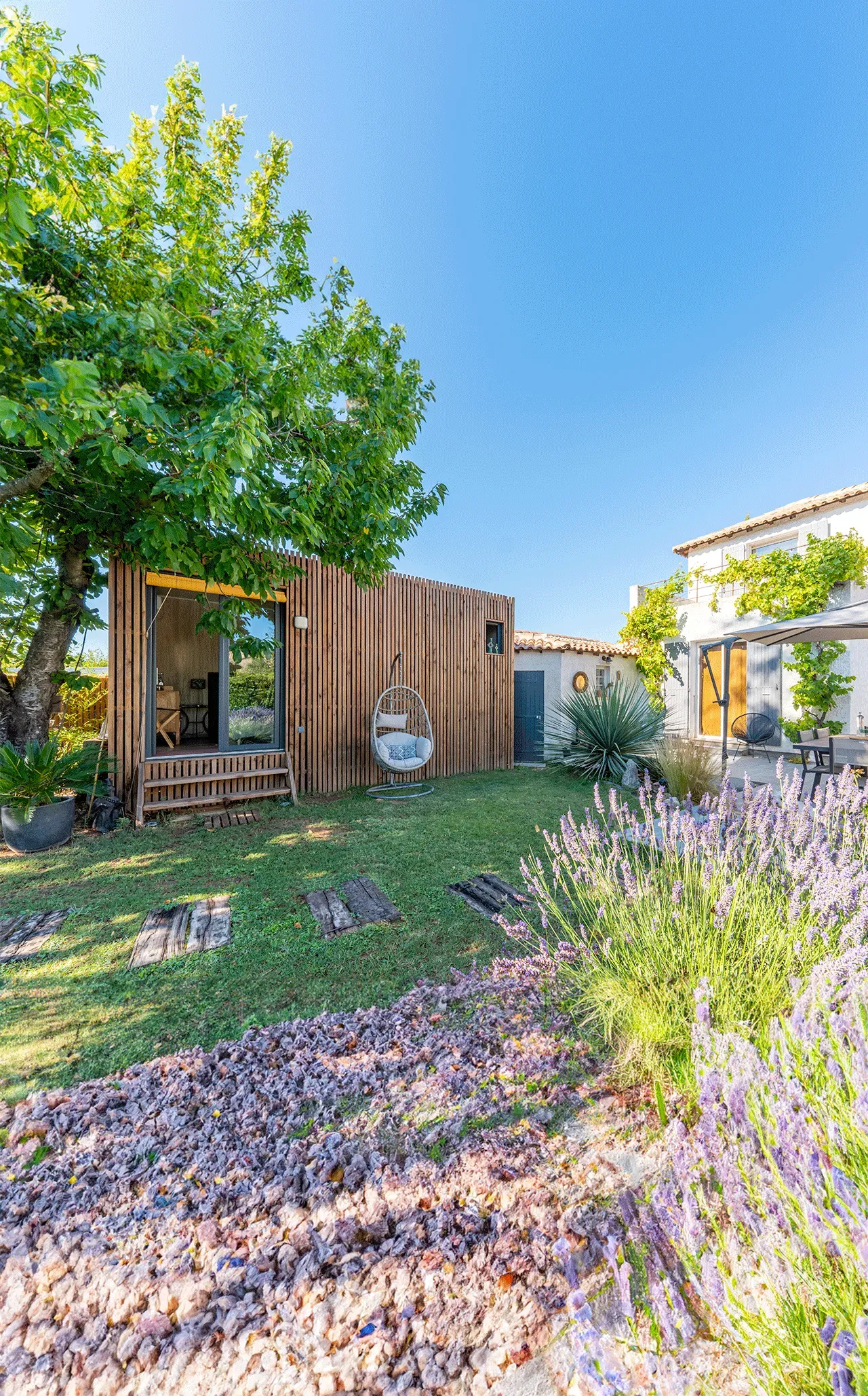 Studio bois compact Greenkub GK15 de 15 m² en ossature bois, alternative à la tiny house, dans un jardin