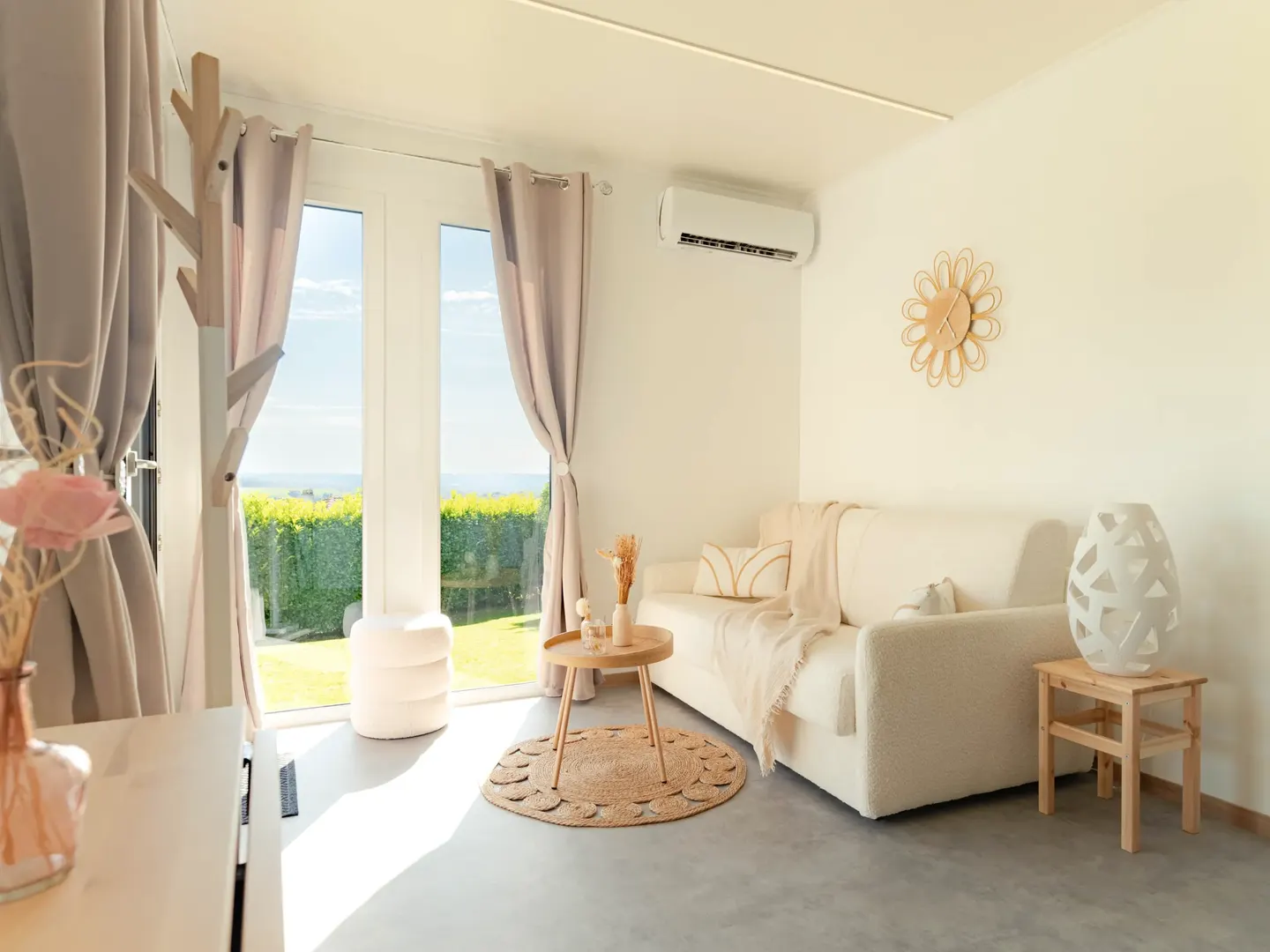 Intérieur d'un studio de jardin Greenkub pensé pour un proche âgé : séjour de plain-pied, sol souple et porte-fenêtre sur le jardin