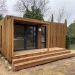 Un studio de jardin en bois avec des marches