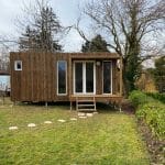 Studio de jardin en bois avec des menuiseries blanches