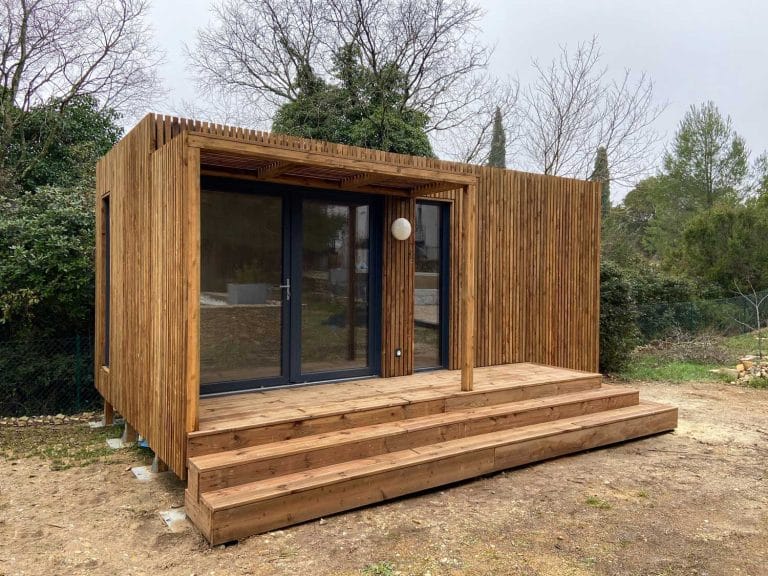 Un studio de jardin en bois avec des marches