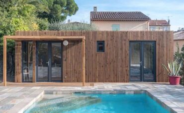 Un pool house en bois de 30m2 au bord d'une piscine