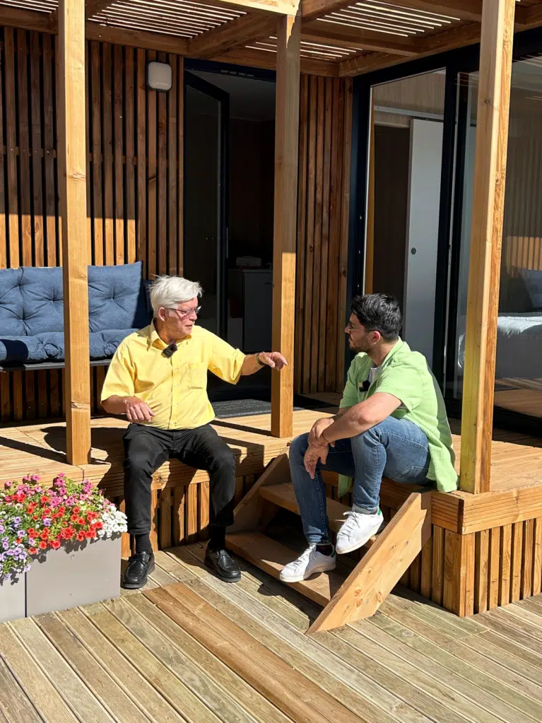 Un père et son fils devant une maison en bois