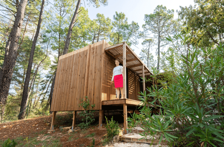 Une femme sur la terrasse de sa maison en bois