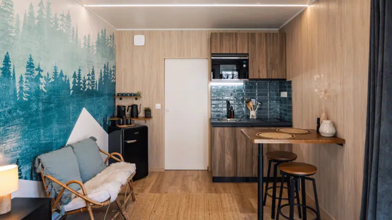 Salon aménagé avec une cuisine dans une petite maison en bois