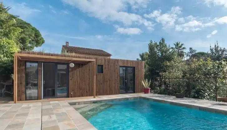 Pool house en bois Greenkub au bord d'une piscine