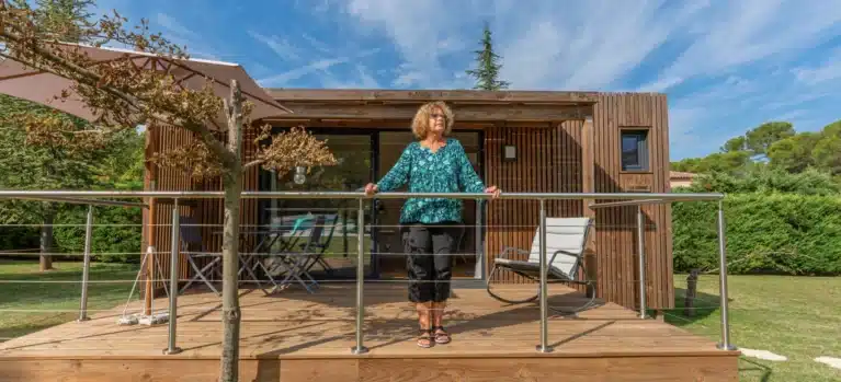 Femme à l'entrée de son bureau de jardin en bois Greenkub
