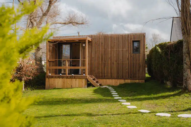 Vue extérieure d’un studio de jardin en bois massif avec bardage bois en Bretagne