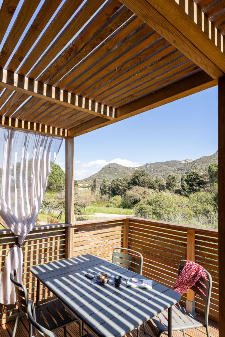 Détail de la terrasse d'un GK20 Greenkub : lames de bois horizontales, montants verticaux et garde-corps ajouré