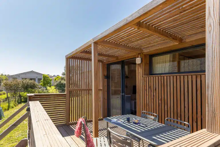 Détail de la terrasse d'un GK20 Greenkub : lames de bois horizontales, montants verticaux et garde-corps ajouré