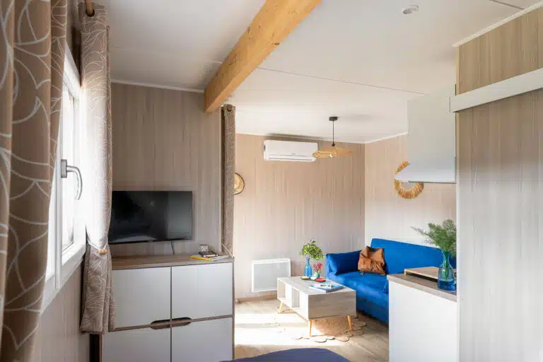 Finitions intérieures d'un studio Greenkub 20m² : lambris bois clair, plafond blanc et mobilier épuré