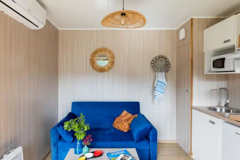 Kitchenette compacte d'un GK20 Greenkub : plan de travail bois, réfrigérateur intégré et rangements muraux