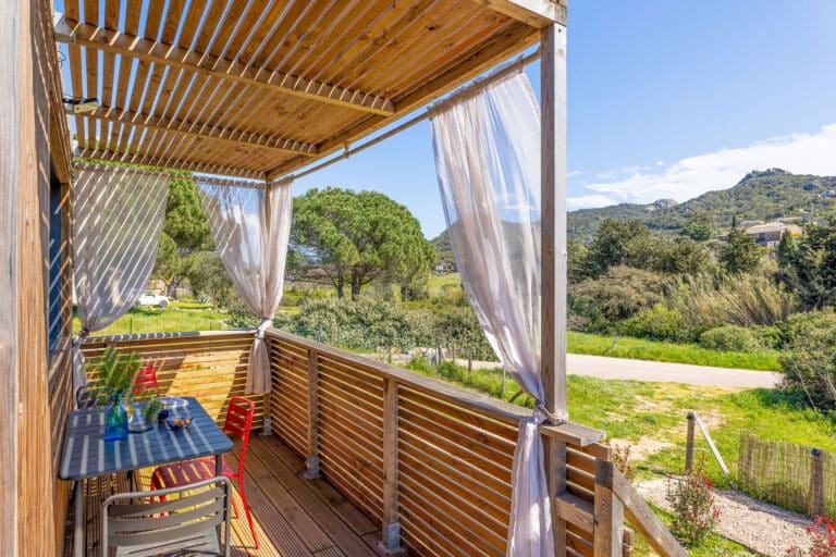 Studio bois Greenkub 20m² avec grande baie vitrée et terrasse, intégré dans un environnement naturel corse