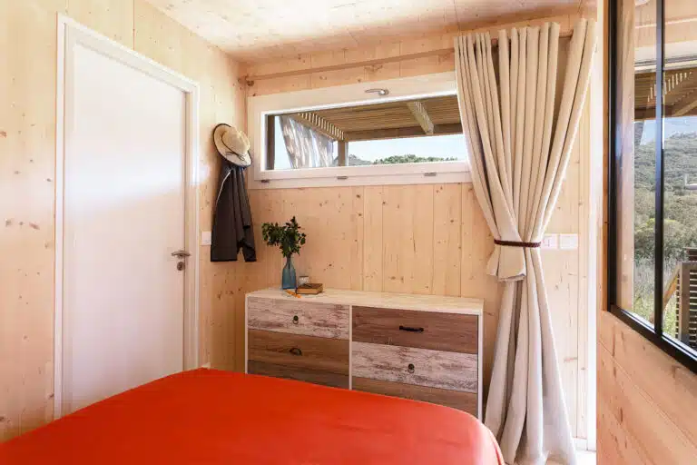 Chambre d'un studio Greenkub GK20 avec lit double, linge de lit rouge corail