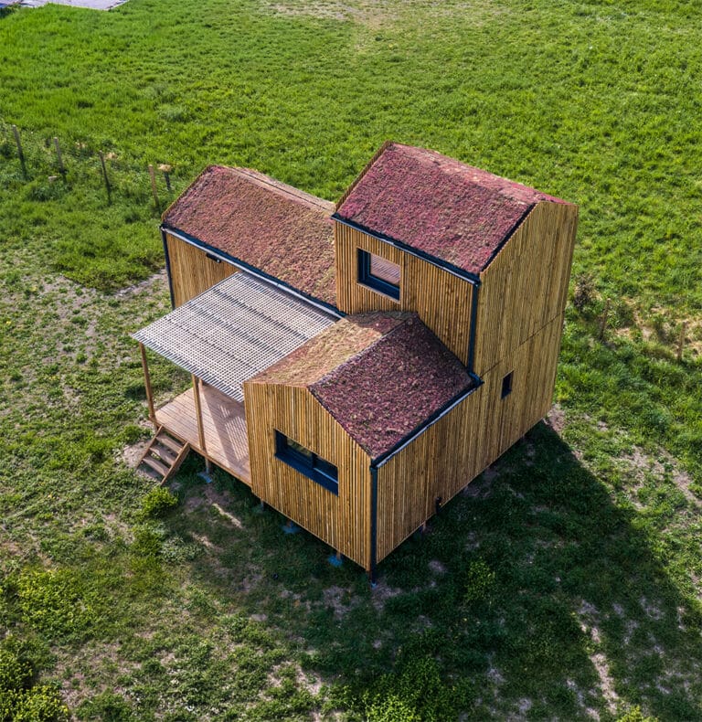 GK50 Greenkub depuis les airs – implantation terrain naturel, composition volumétrique bois et toits verts, Allier