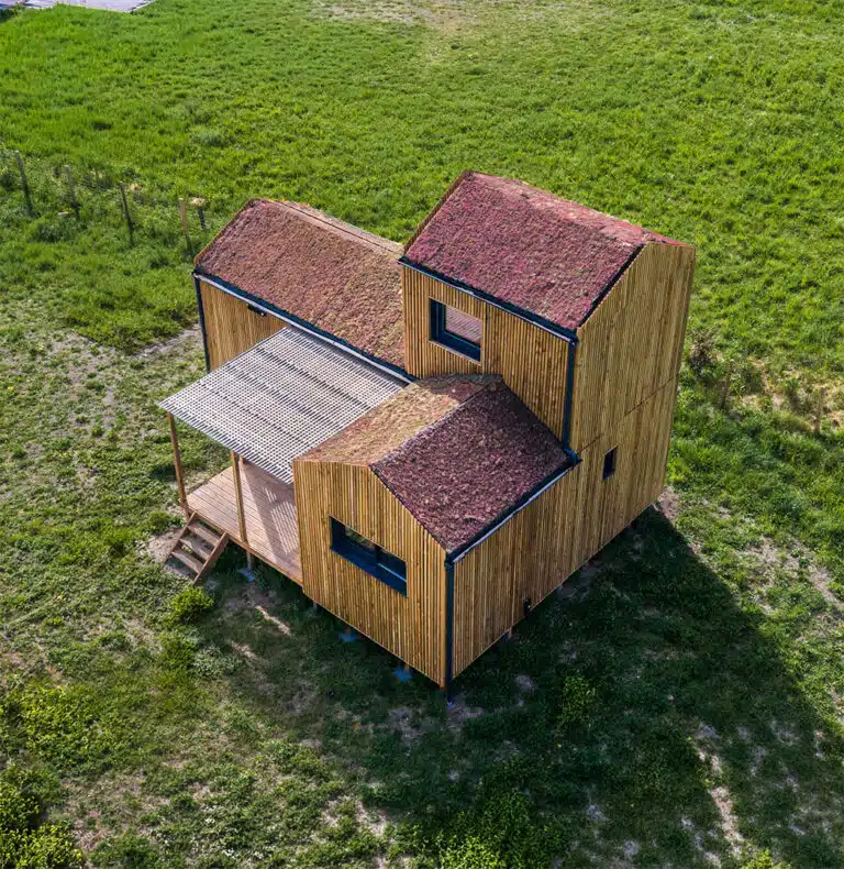 GK50 Greenkub depuis les airs – implantation terrain naturel, composition volumétrique bois et toits verts, Allier