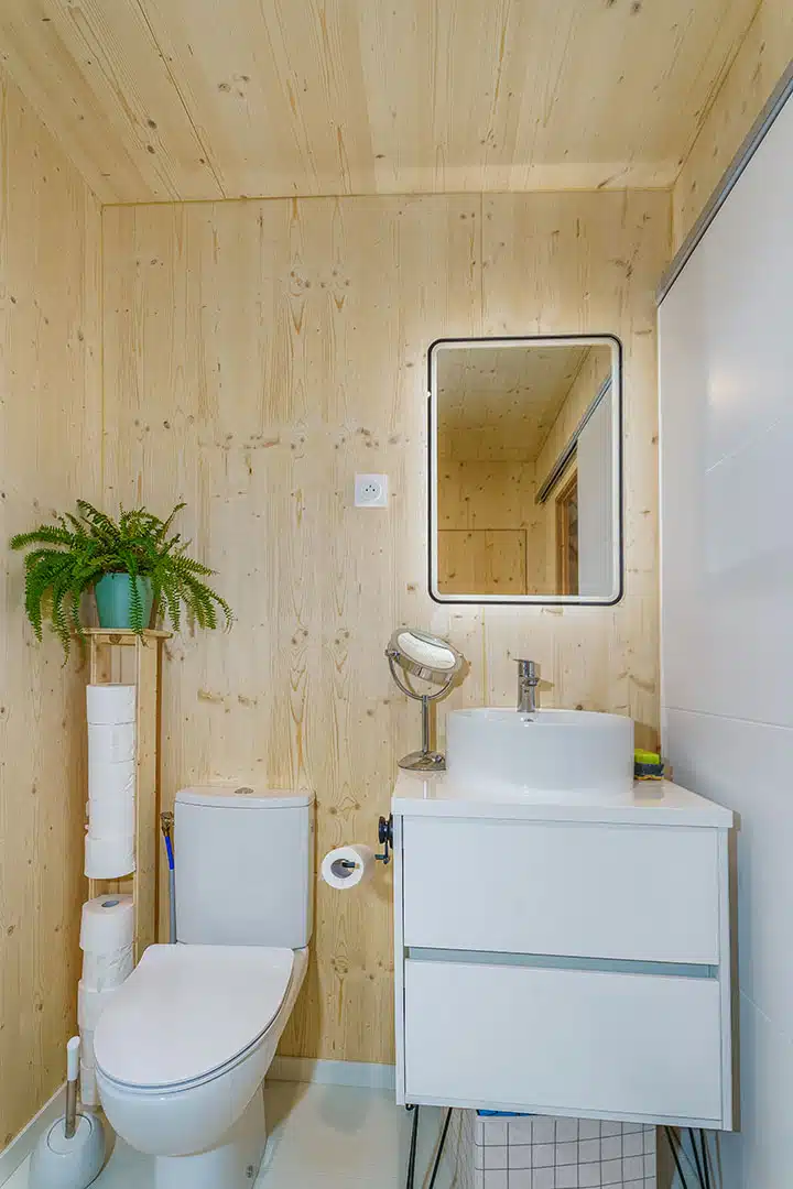 Salle d'eau maison modulaire bois Greenkub – vasque blanche, WC, miroir LED, murs CLT épicéa naturel