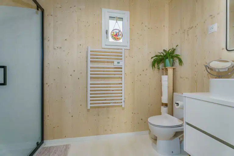 salle de bain maison modulaire 50m² – parois bois CLT, meuble vasque suspendu blanc, plantes vertes