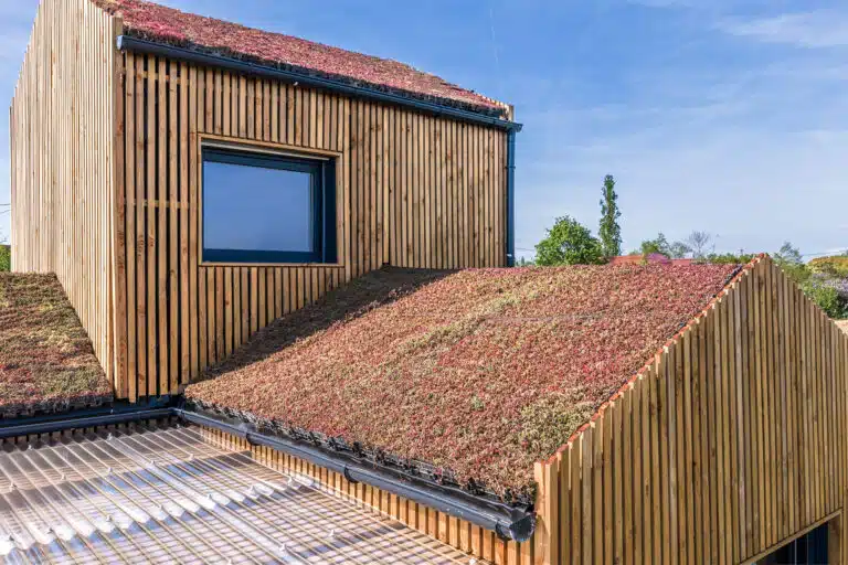 Maison modulaire bois Greenkub GK50 – façade bardage douglas vertical, toits végétalisés, plots métalliques, Allier